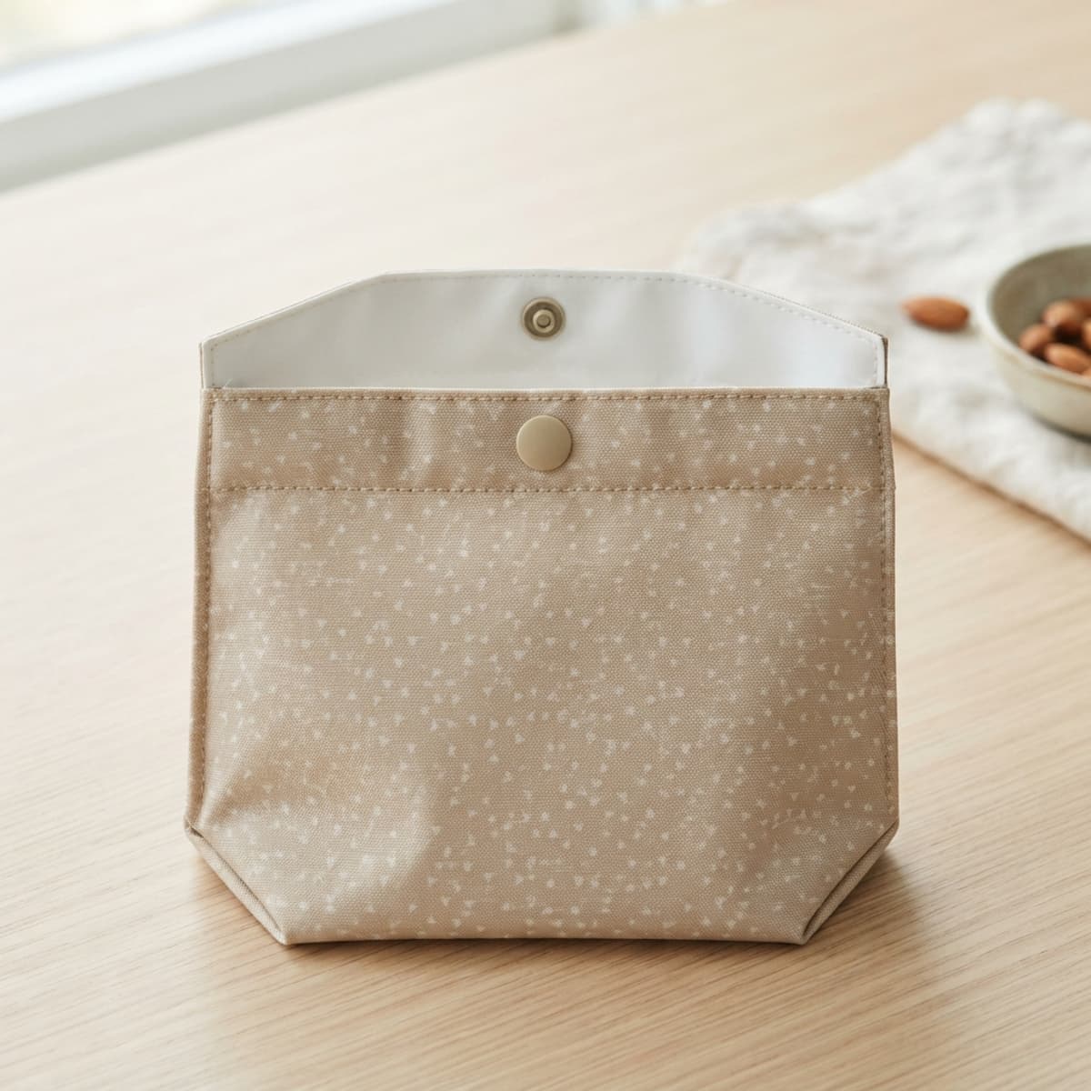 Sac de congélation en tissu PUL posé à plat avec ouverture large et fermeture à bouton-pression.
